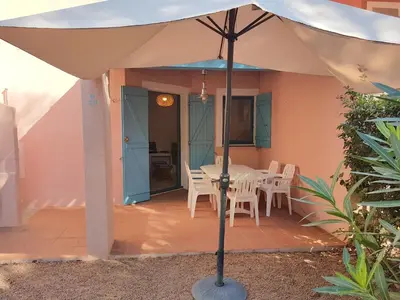 a white umbrella on a patio with a table and chairs at ST CYPRIEN D29 -4/5 pers- à 250m de la plage de sable Saint Cyprien in Lecci