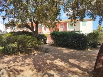 a pink house with a tree in the yard at ST CYPRIEN D29 -4/5 pers- à 250m de la plage de sable Saint Cyprien in Lecci