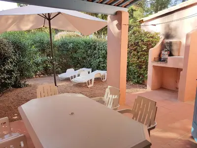 a patio with a white table and chairs and an umbrella at ST CYPRIEN D29 -4/5 pers- à 250m de la plage de sable Saint Cyprien in Lecci