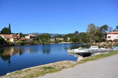 a boat docked at a dock on a lake at ST CYPRIEN D29 -4/5 pers- à 250m de la plage de sable Saint Cyprien in Lecci
