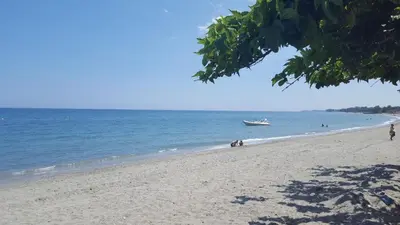 a beach with a boat in the water at SANTA-LUCIA in Santa-Lucia-di-Moriani