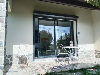 a glass door with a table and chairs on a patio at SANTA-LUCIA in Santa-Lucia-di-Moriani