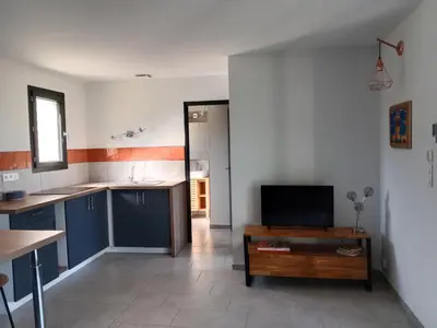 a kitchen with blue cabinets and a tv on a table at SANTA-LUCIA in Santa-Lucia-di-Moriani