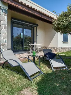 two chairs and a table in front of a house at SANTA-LUCIA in Santa-Lucia-di-Moriani