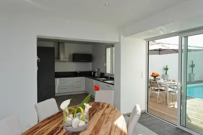a kitchen and dining room with a wooden table at Villa Leccia vue mer piscine chauffée Bonifacio in Bonifacio