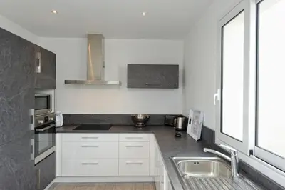 a kitchen with white cabinets and a sink at Villa Leccia vue mer piscine chauffée Bonifacio in Bonifacio