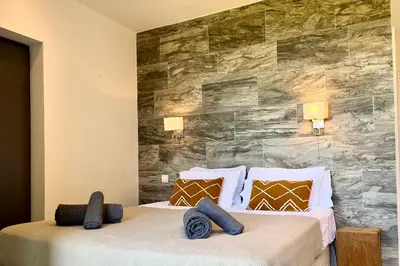 a bedroom with two beds and a stone wall at Villa Leccia vue mer piscine chauffée Bonifacio in Bonifacio