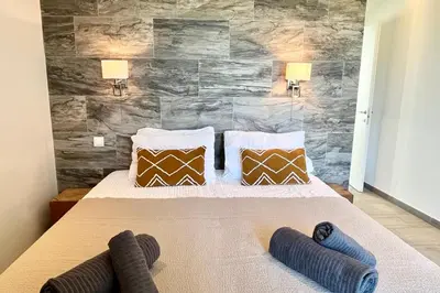 a bedroom with a large bed with two pillows at Villa Leccia vue mer piscine chauffée Bonifacio in Bonifacio