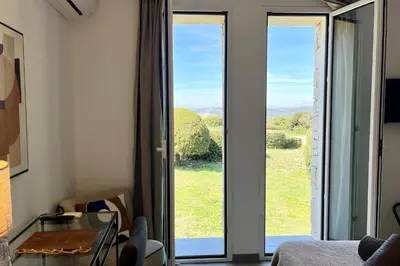 a room with a room with sliding glass doors at Villa Leccia vue mer piscine chauffée Bonifacio in Bonifacio