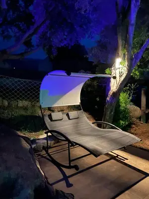a bench sitting in front of a tree at night at Villa A Volta in Urtaca