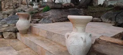 two large white vases sitting on a stone path at Villa A Volta in Urtaca