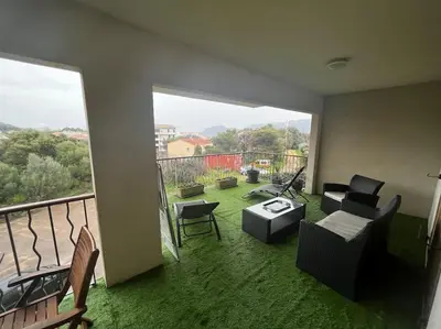 a living room with a view of a balcony at Trés Bel appartement de 105 M2 et 45 M2 de terrasse à 100 m du port in Porto-Vecchio