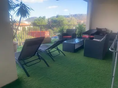 a room with chairs and a table and a balcony at Trés Bel appartement de 105 M2 et 45 M2 de terrasse à 100 m du port in Porto-Vecchio