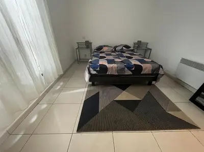 a bedroom with a bed sitting on a tiled floor at Trés Bel appartement de 105 M2 et 45 M2 de terrasse à 100 m du port in Porto-Vecchio