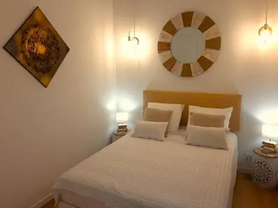 a bedroom with a bed with two lamps and a mirror at Piccula Casa in Albitreccia