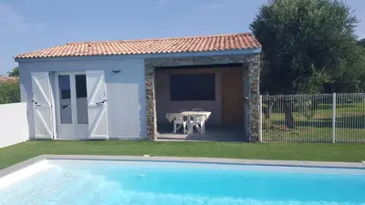 a small shed with a table and a pool at Les bougainvilliers in Penta-di-Casinca