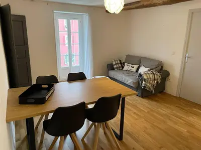 a living room with a table and chairs and a couch at Charmant T3 Centre ville Corté in Corte