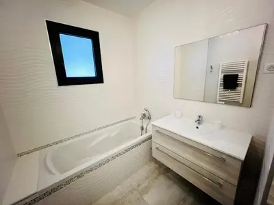 a bathroom with a tub and a sink and a mirror at Villa Livia Porticcio piscine 500m plage in Porticcio