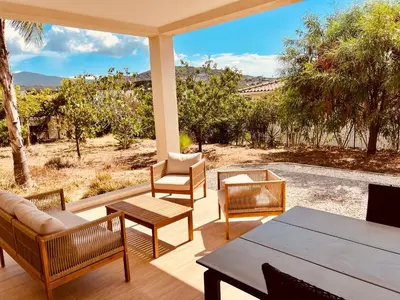 a patio with chairs and a table with a view at Villa Livia Porticcio piscine 500m plage in Porticcio