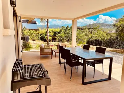 a table and chairs on a patio with a view at Villa Livia Porticcio piscine 500m plage in Porticcio