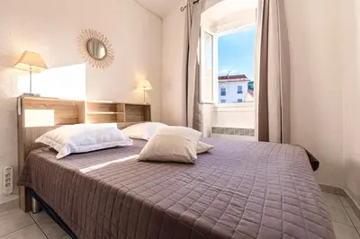 a bedroom with a large bed with a window at Alla Casa - Appt pour 6 avec terrasse in Aregno