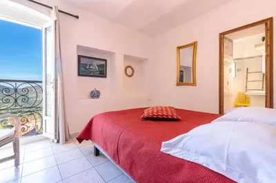 a bedroom with a bed and a view of the ocean at Alla Casa - Appt pour 6 avec terrasse in Aregno