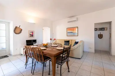 a dining room and living room with a table and chairs at Alla Casa - Appt pour 6 avec terrasse in Aregno
