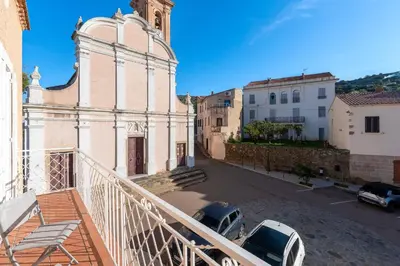 a building with a clock tower and cars parked in a street at Alla Casa - Appt pour 6 avec terrasse in Aregno