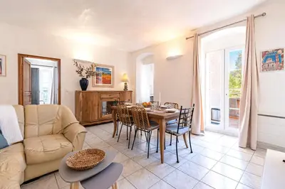 a living room with a table and chairs and a couch at Alla Casa - Appt pour 6 avec terrasse in Aregno