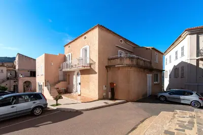 two cars parked in front of a brick building at Alla Casa - Appt pour 6 avec terrasse in Aregno