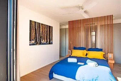 a bedroom with a large blue bed with yellow pillows at VILLA ISULA BELLA in Porto-Vecchio