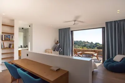 a living room with a table and blue chairs at VILLA ISULA BELLA in Porto-Vecchio