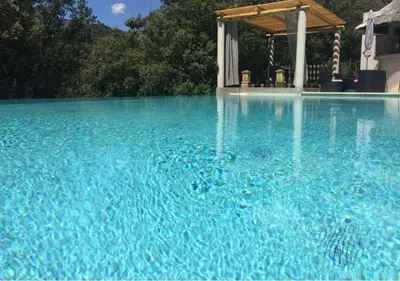 a large pool of blue water with a gazebo at A Furtezza in Soveria