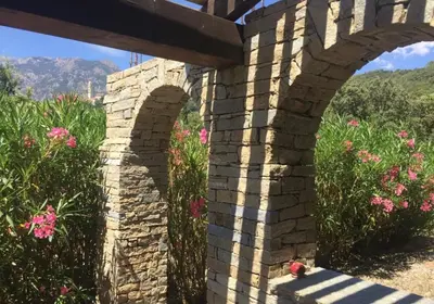 a brick bridge with pink flowers in the background at A Furtezza in Soveria