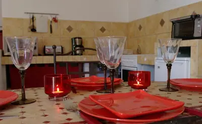a kitchen table with red plates and wine glasses at A Furtezza in Soveria
