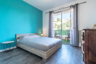 a bedroom with a bed and a blue wall at Chapelle des Grecs - 1km de la plage in Ajaccio