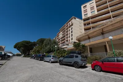 a row of cars parked in a parking lot next to a building at Chapelle des Grecs - 1km de la plage in Ajaccio