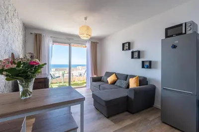 a living room with a couch and a table and a refrigerator at Chapelle des Grecs - 1km de la plage in Ajaccio