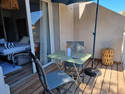 a table and a chair on a porch with an umbrella at Fiori di flore in Lecci