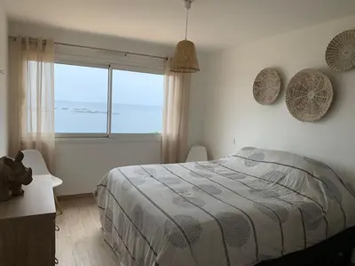 a bedroom with a bed and a large window at Ajaccio maison bord de mer dans résidence avec piscine in Ajaccio