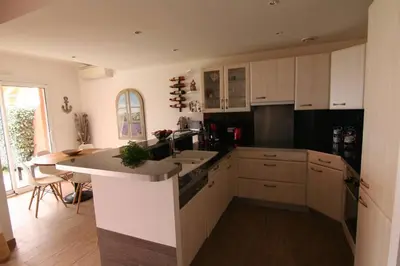 a kitchen with white cabinets and a counter top at Ajaccio maison bord de mer dans résidence avec piscine in Ajaccio