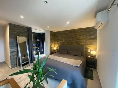 a bedroom with a bed and a brick wall at Maison de caractère, Zilia, au pied du Montegrossu in Zilia