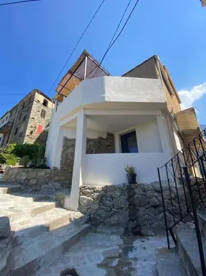 a white house with some stairs in front of it at Maison de caractère, Zilia, au pied du Montegrossu in Zilia