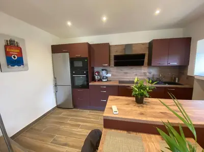 a kitchen with brown cabinets and a wooden table at Maison de caractère, Zilia, au pied du Montegrossu in Zilia