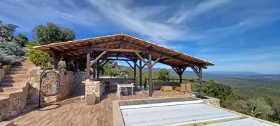 a gazebo with a table and chairs on a deck at U CASEDDU- Villa piscine privée chauffée- vue mer- clim-wifi in Sari Solenzara