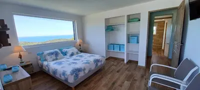 a bedroom with a bed and a large window at U CASEDDU- Villa piscine privée chauffée- vue mer- clim-wifi in Sari Solenzara