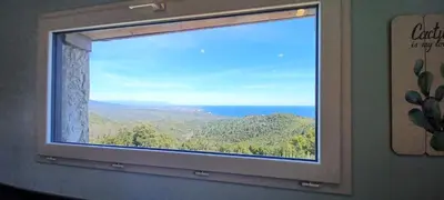 a window with a view of the ocean at U CASEDDU- Villa piscine privée chauffée- vue mer- clim-wifi in Sari Solenzara