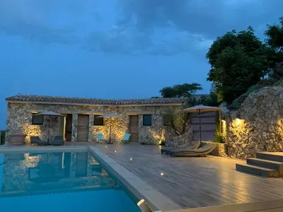 a villa with a swimming pool at night at U CASEDDU- Villa piscine privée chauffée- vue mer- clim-wifi in Sari Solenzara