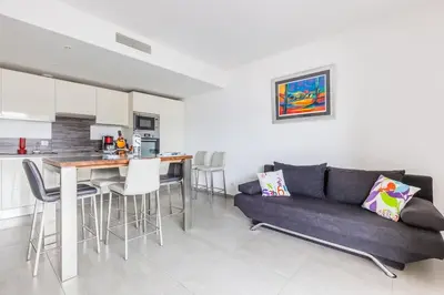 a living room with a couch and a kitchen at T2 d'exception 100m plage terrasse vue mer et montagnes in Propriano