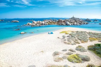 a group of people sitting on a white beach at T2 d'exception 100m plage terrasse vue mer et montagnes in Propriano